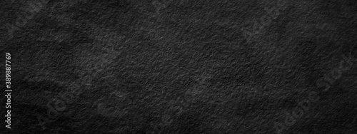 Abstract black stone wall, background - in the form of a rough embossed stone surface, closeup