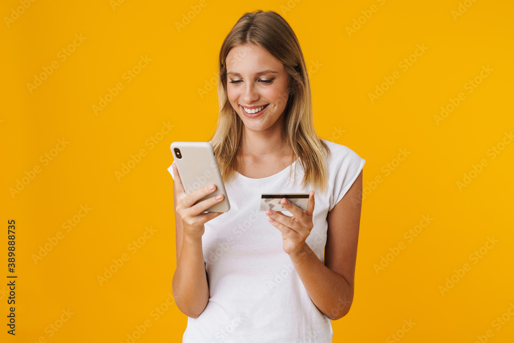 Cheerful blonde girl using mobile phone and credit card Cheerful blonde girl using mobile phone and credit card