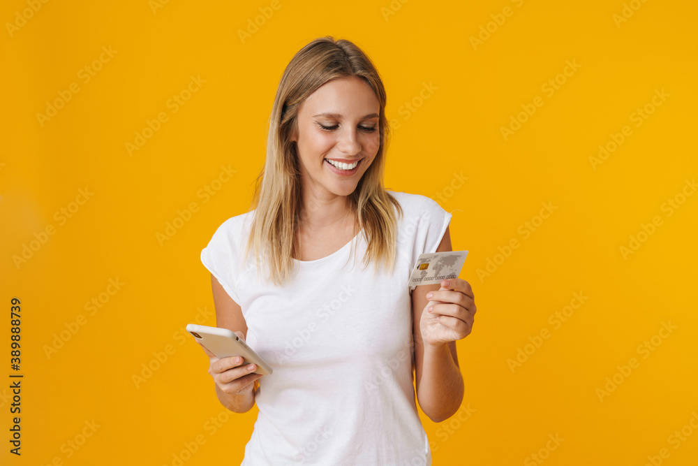 Cheerful blonde girl using mobile phone and credit card Cheerful blonde girl using mobile phone and credit card