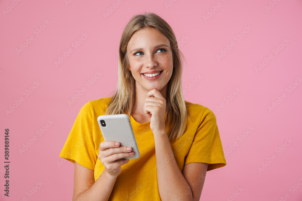 Cheerful blonde girl smiling and using mobile phone Cheerful blonde girl smiling and using mobile phone