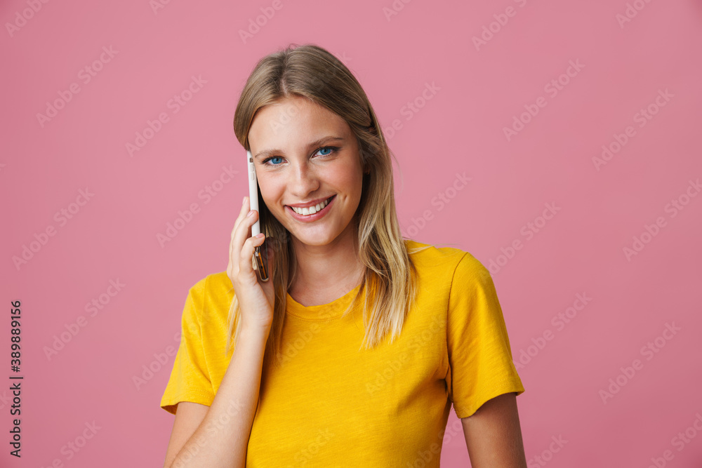Cheerful blonde girl smiling and talking on mobile phone Cheerful blonde girl smiling and talking on mobile phone