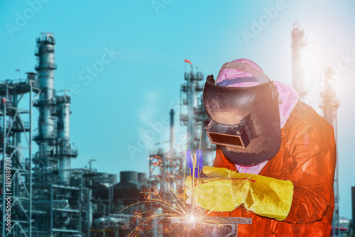 Industrial welding, Double exposure Industry worker at the factory welding steel structure on Oil Refinary background.