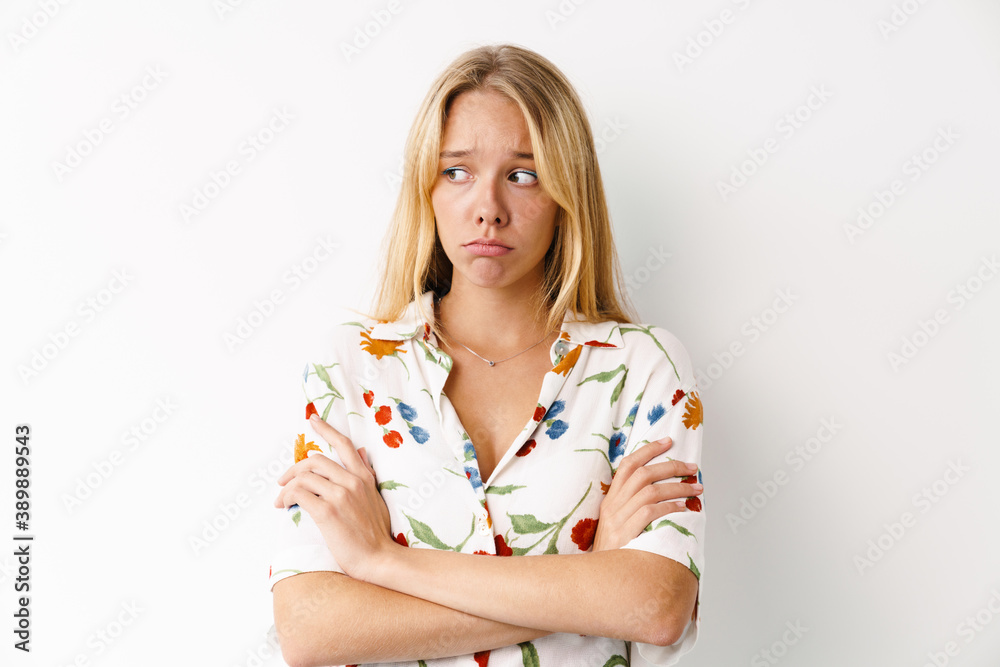 Unhappy beautiful girl posing with arms crossed at camera Unhappy beautiful girl posing with arms crossed at camera