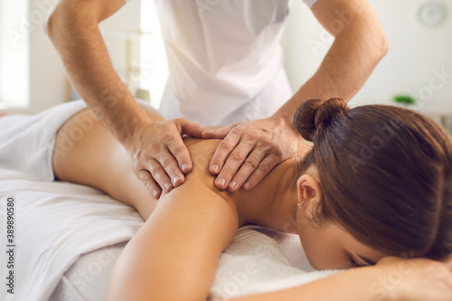 Hands of professional chiropractor or masseur making massage of back and shoulders for woman