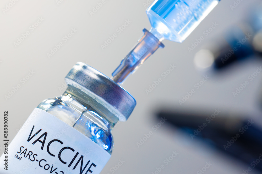 Covid-19 vaccine bottle with a syringe taking the vaccine from it Covid-19 vaccine bottle with a syringe taking the vaccine from it