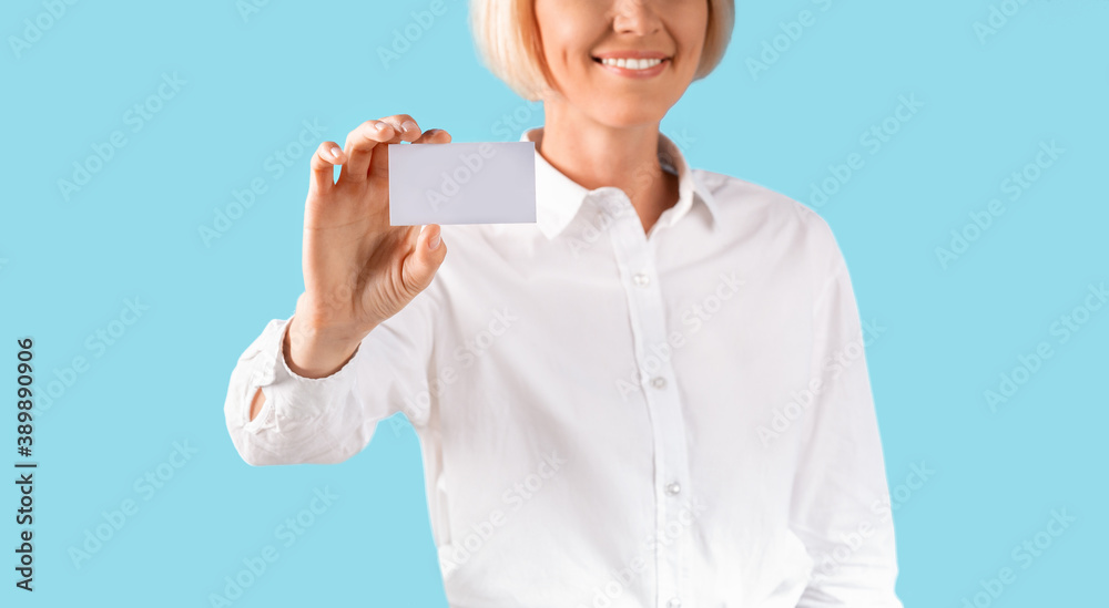 Closeup of businesswoman showing blank busines card with space for your design over blue studio background, panorama Closeup of businesswoman showing blank busines card with space for your design over blue studio background, panorama