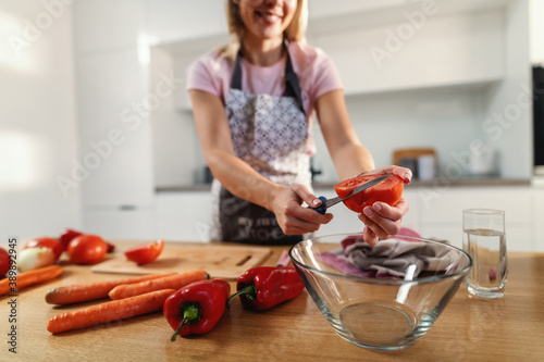 Close-up of woman cutting organic tomato for healthy lunch.