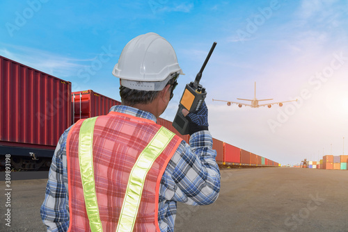 The man worker with hand holding communicationg radio and control container in port, Walkie Talkie photo