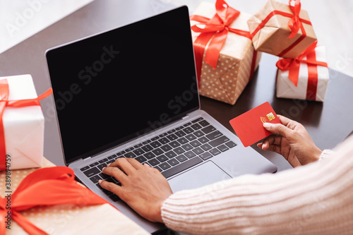 Black woman using computer and credit card at home