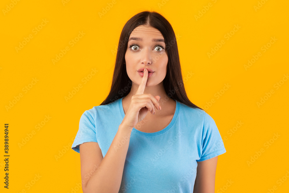 Woman putting finger on his lips, making silence sign Woman putting finger on his lips, making silence sign