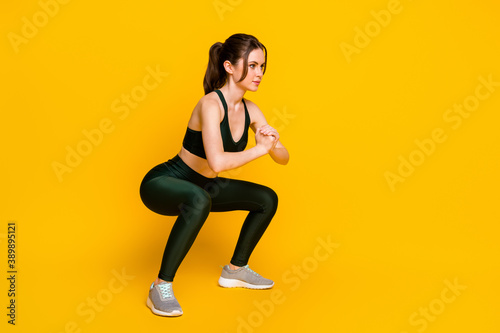 Full length body size profile side view of her she nice focused sportive girl doing sit-ups practicing isolated on bright yellow color background