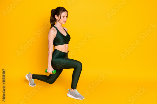 Full length body size view of nice attractive strong focused girl using dumbbells doing sit-ups isolated over bright yellow color background
