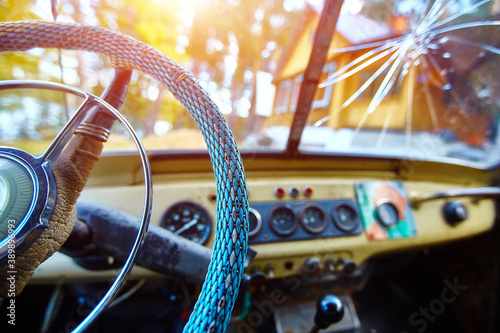 Vintage interior of an old car with a retro dashboard and steering wheel in a PVC cover