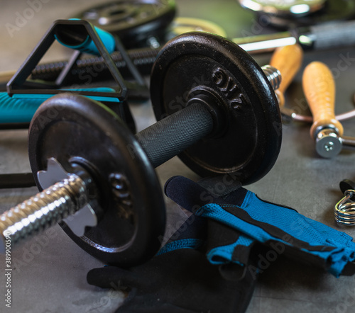 Items for training at the gym or at home. Dumbbells, Push up bars, weight plates of different sizes, jump rope, training gloves and hand grips.