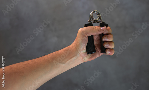 Hand grip for training the hand and arm muscles. White man's arm training. photo