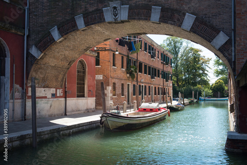 scorcio di un canale minore di Venezia, con un edificio industriale di mattoni rossi, ex manifattura 