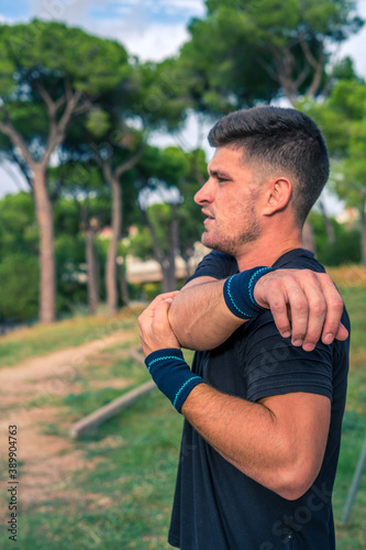 Vertical shot of a handsome sportsman in a park during training photo