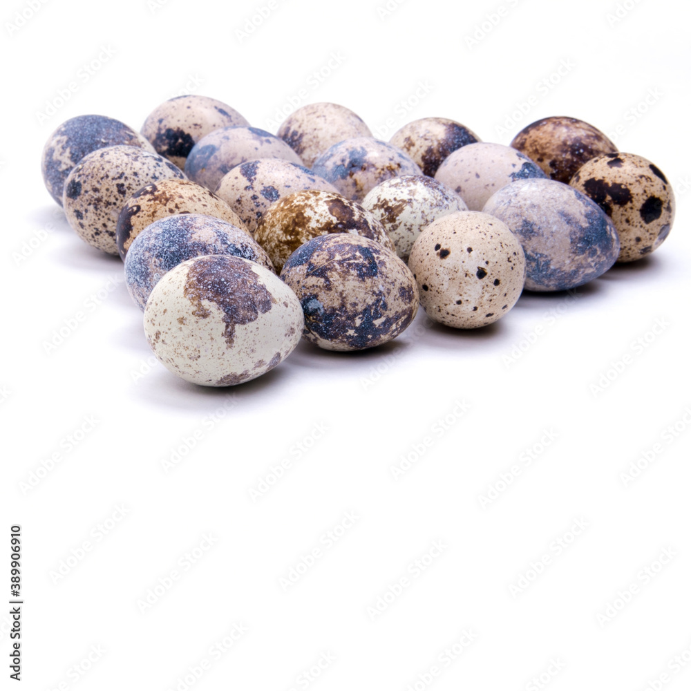 Quail eggs laid out in a triangle shape, close-up on a white background, copy space