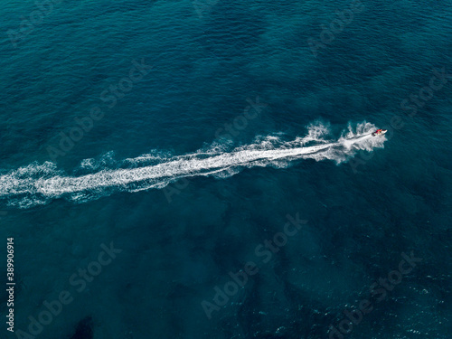 Aerial view of a jet ski cruising at full speed. Fun and holidays, water sport. Sea and waves © Naeblys