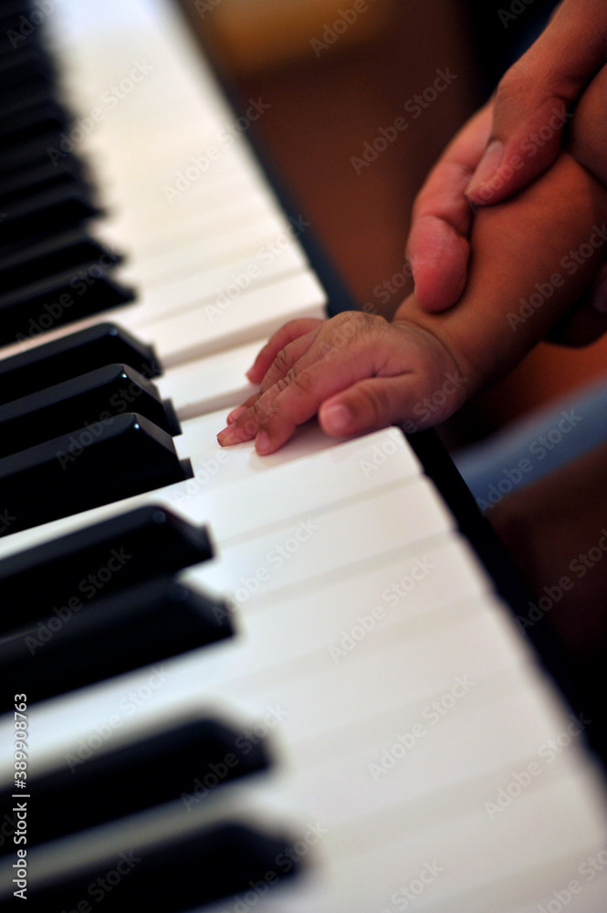 Hand Little son to play the piano, kid on piano keyboard - Image