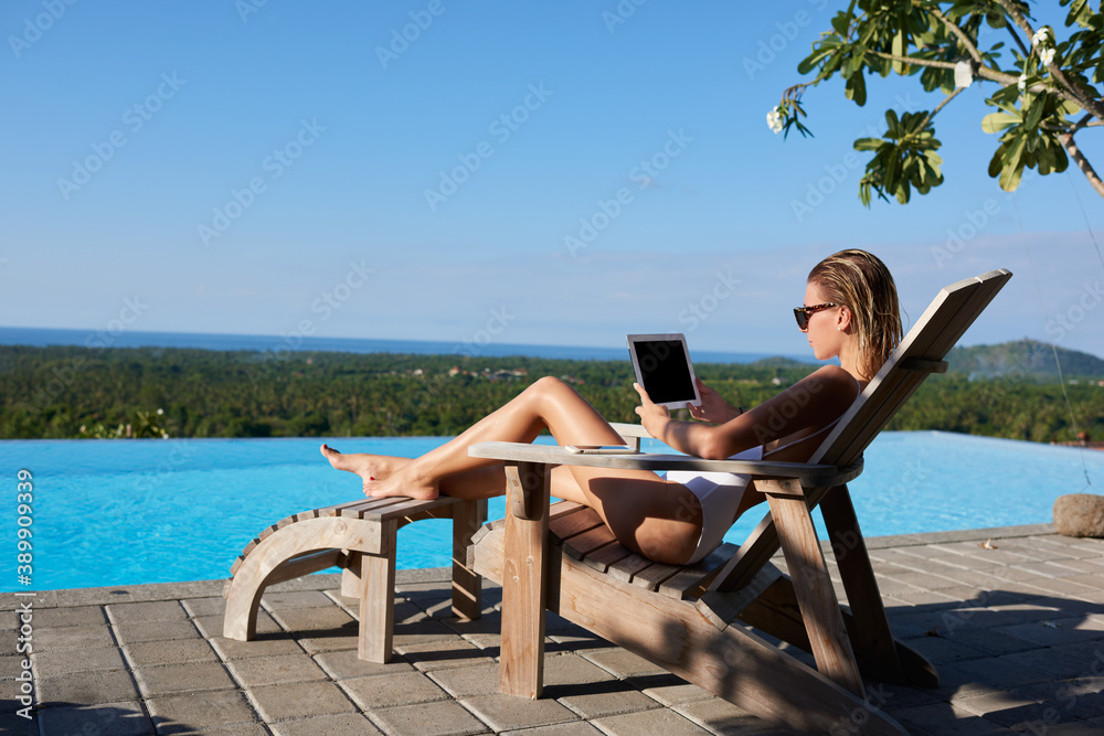 Woman browsing tablet on lounger