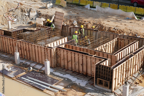 KUALA LUMPUR, MALAYSIA -MARCH 5, 2020: Building ground beam under construction using temporary timber plywood formwork at the site. Reinforced by the reinforcement steel to strengthen the structure.  photo