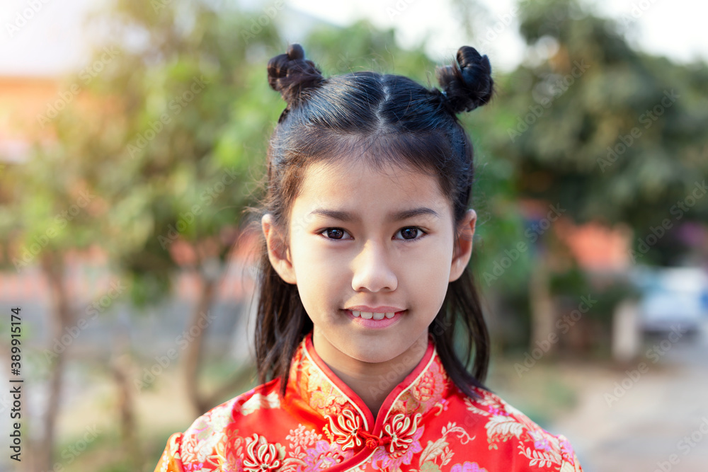 Little Asian girl in Chinese dress, portrait, outdoors Little Asian girl in Chinese dress, portrait, outdoors