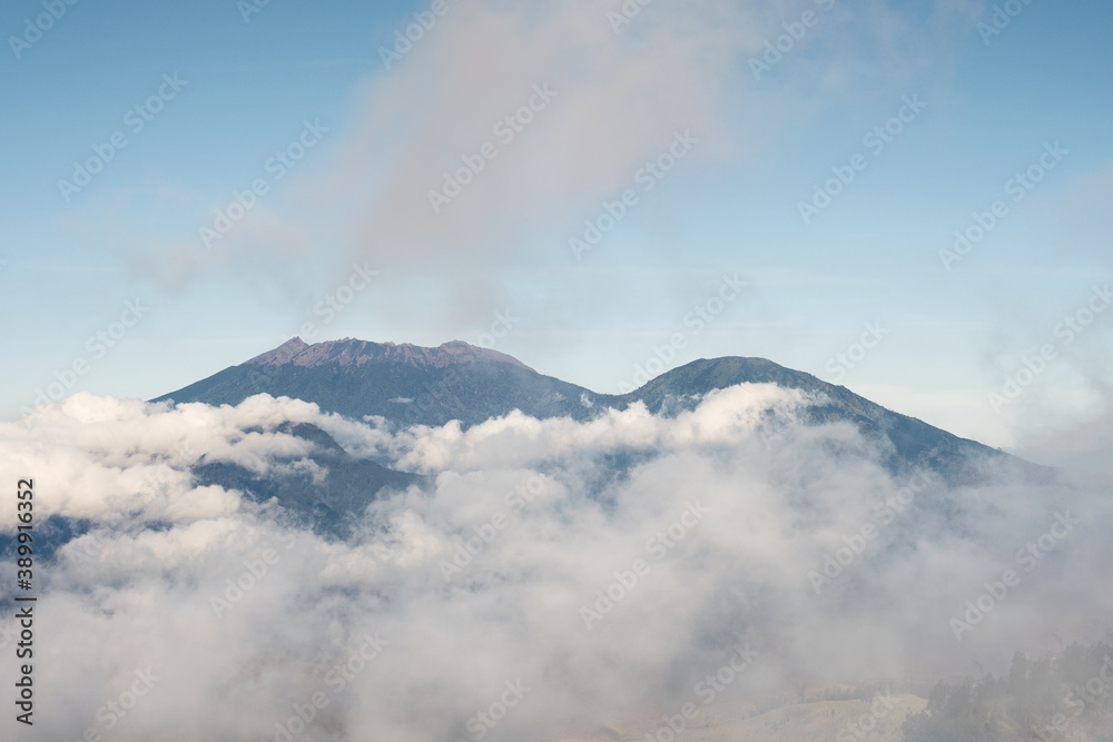 Active mount volcano in foggy and blue sky in the morning at Kawah Ijen Active mount volcano in foggy and blue sky in the morning at Kawah Ijen