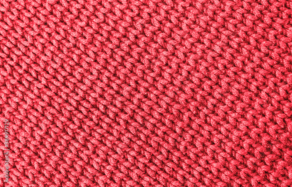 Knitted pink background. Yarn texture. Diagonal knitting