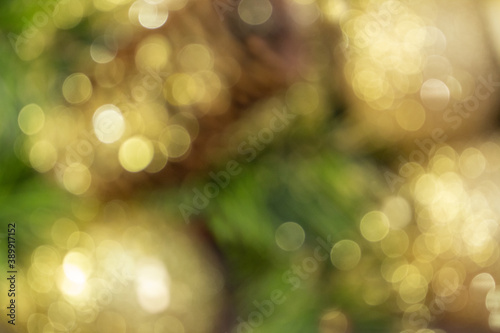 Abstract blurred shiny yellow Christmas balls and cone with barks and pine branches. New year card. Background