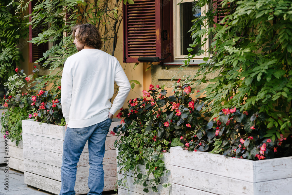 Man wearing white sweatshirt or hoodie for mock up, logo designs or design prints with with free space on the city streets. Man wearing white sweatshirt or hoodie for mock up, logo designs or design prints with with free space on the city streets.