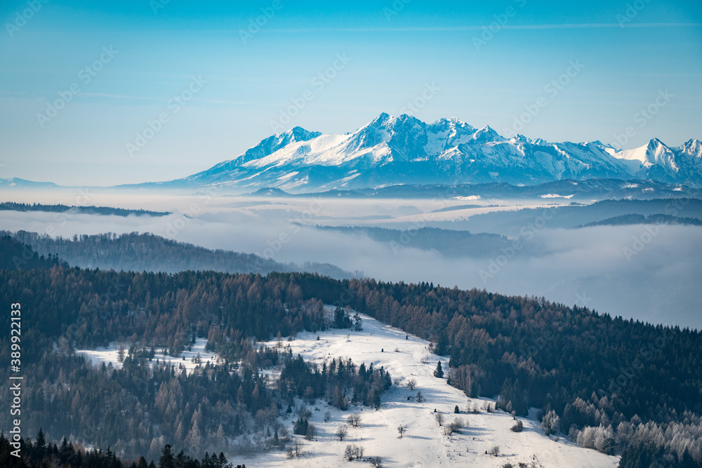 Morning view of Tatra Mountains in winter. Fogs in valleys.