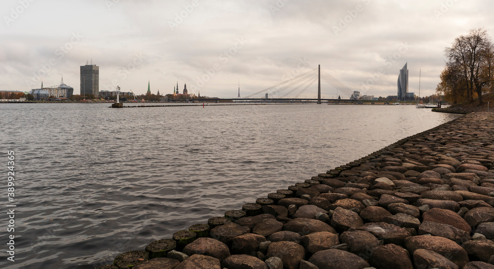 Fototapeta premium View of the city from the rocky shore, you can see the pier and the suspension bridge