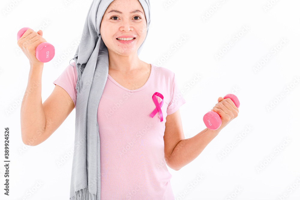 Asian women muslim religious women in hijab attach a pink ribbon to their tops. Doing exercise by lifting pink dumbbells. breast cancer concept, cancer prevention concept. Acne and dark spots. Asian women muslim religious women in hijab attach a pink ribbon to their tops. Doing exercise by lifting pink dumbbells. breast cancer concept, cancer prevention concept. Acne and dark spots.