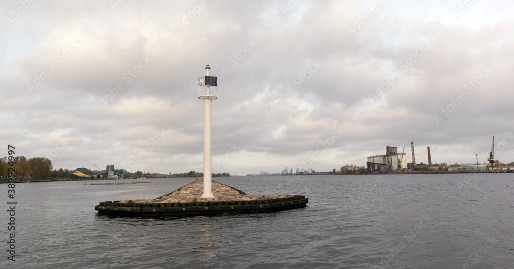 White lighthouse on a stone pier in Riga, on the river Daugava
