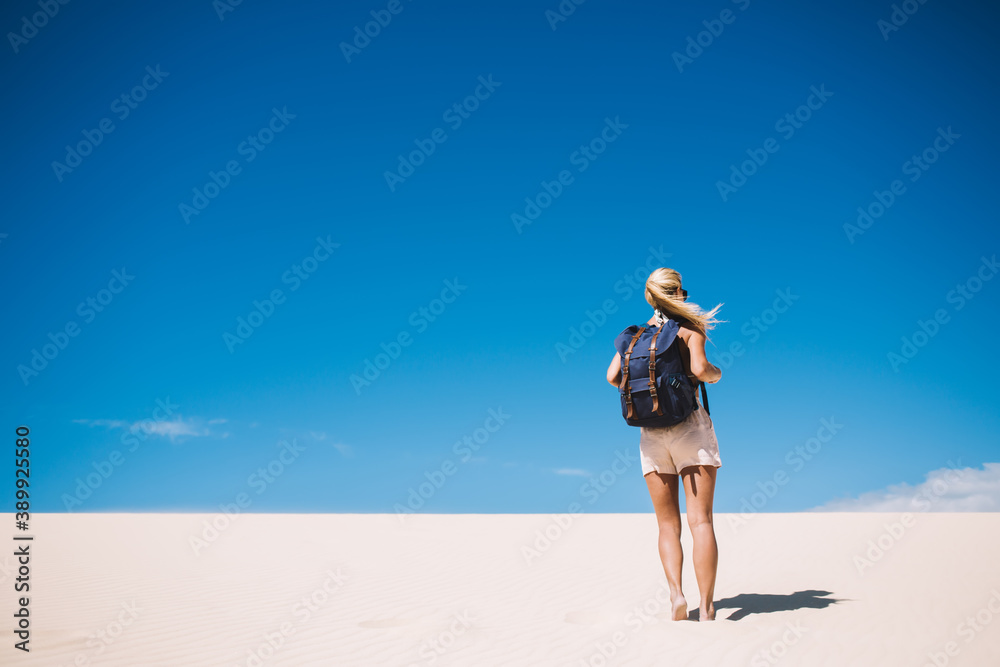 Back view of female with backpack exploring arid land of desert on summer vacation in nature landmark, woman wanderlust walking with rucksack in White sands national park near dunes coming to horizon Back view of female with backpack exploring arid land of desert on summer vacation in nature landmark, woman wanderlust walking with rucksack in White sands national park near dunes coming to horizon