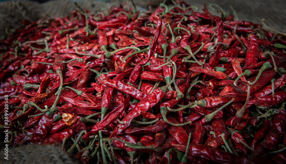 Fototapeta premium many red hot spice chili pepper on a market in a big container, closeup 