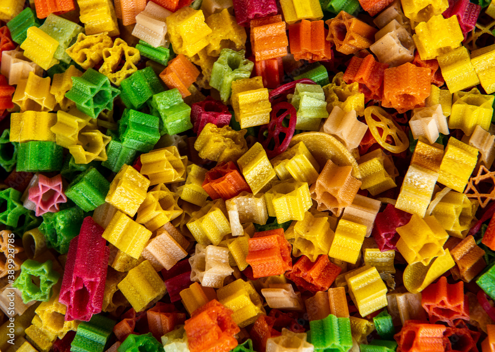 colorful pasta on a market in a big sack, natural colored in many different colors, yellow, green, red  and orange can be used as background or wallpaper 
