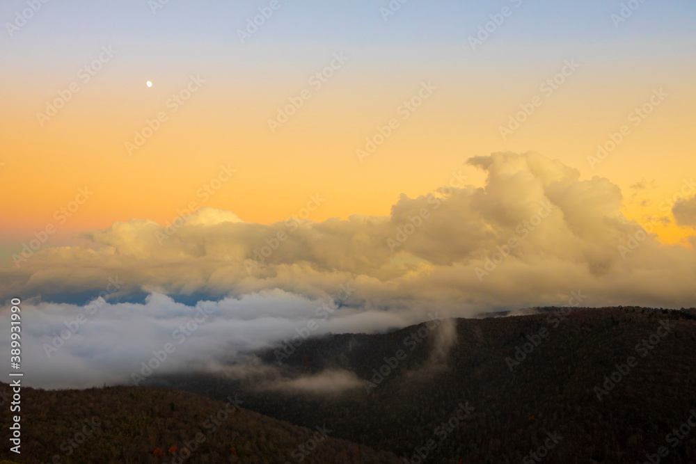 The moon and fog banks sit over the Blue Ridge Mountains of North Carolina.