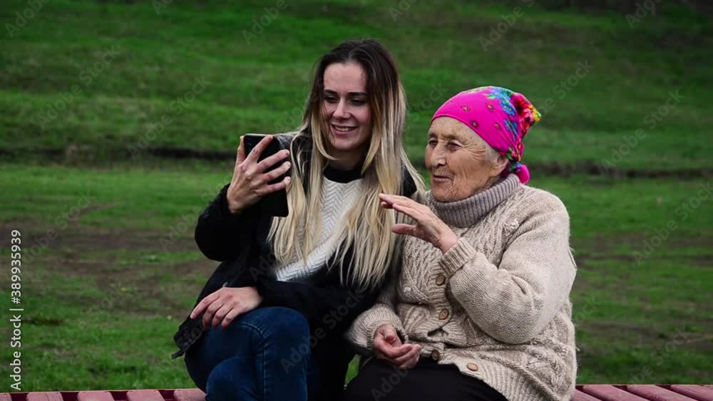 An old grandmother communicates with her granddaughter via video link during social distancing during the period of quarantine restrictions. Happy grandmother with granddaughter talking by video call An old grandmother communicates with her granddaughter via video link during social distancing during the period of quarantine restrictions. Happy grandmother with granddaughter talking by video call