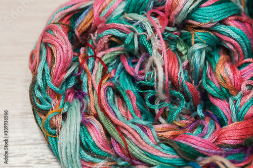 Multicolored embroidery threads are intertwined in a pigtail. Materials for creativity and needlework in vintage style.