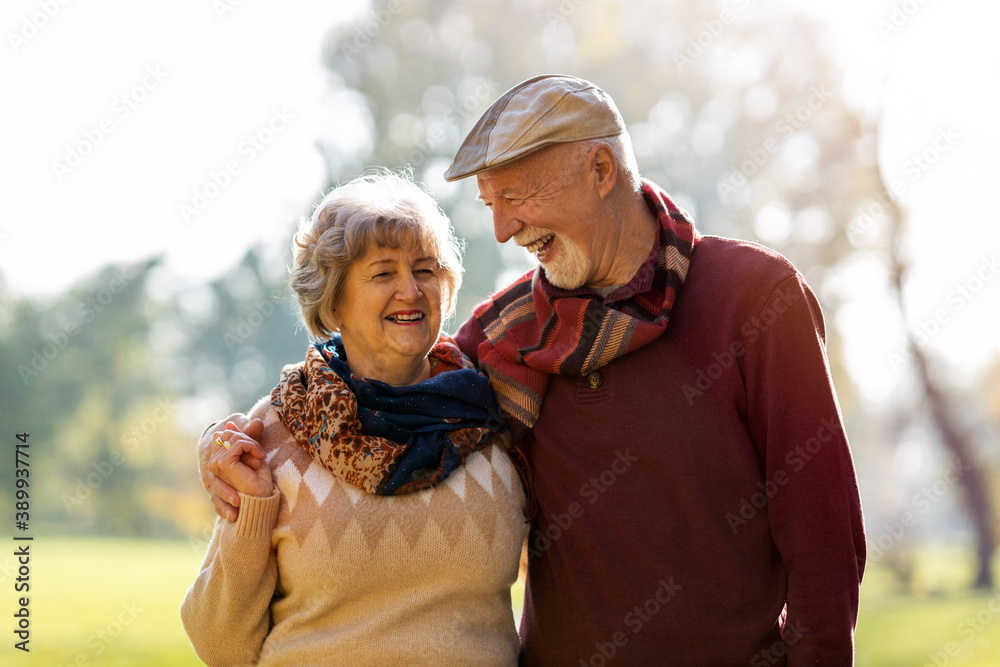Happy senior couple spending time together in beautiful city park in autumn Happy senior couple spending time together in beautiful city park in autumn