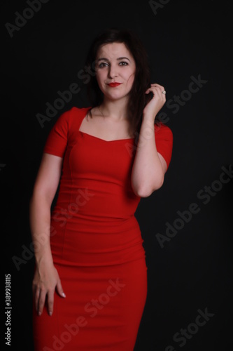 sexy attractive brunette in red skinny dress isolated on black background. studio shoot. emotional actress. . 