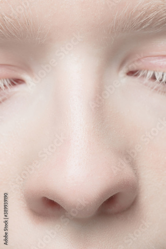 Nose and eyelid. Close up portrait of beautiful albino female model. Parts of face and body. Beauty, fashion, skincare, cosmetics, wellness concept. Copyspace. Well-kept skin, fresh look, details.