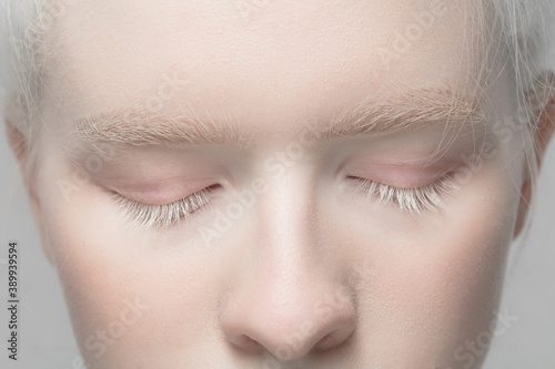 Nose and eyelid. Close up portrait of beautiful albino female model. Parts of face and body. Beauty, fashion, skincare, cosmetics, wellness concept. Copyspace. Well-kept skin, fresh look, details. photo