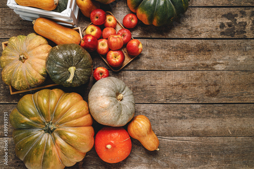 Pumpkins and red apples on wooden background