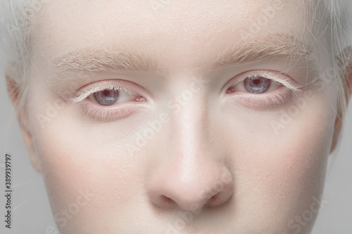 Fototapeta Naklejka Na Ścianę i Meble -  Nose and eyelid. Close up portrait of beautiful albino female model. Parts of face and body. Beauty, fashion, skincare, cosmetics, wellness concept. Copyspace. Well-kept skin, fresh look, details.