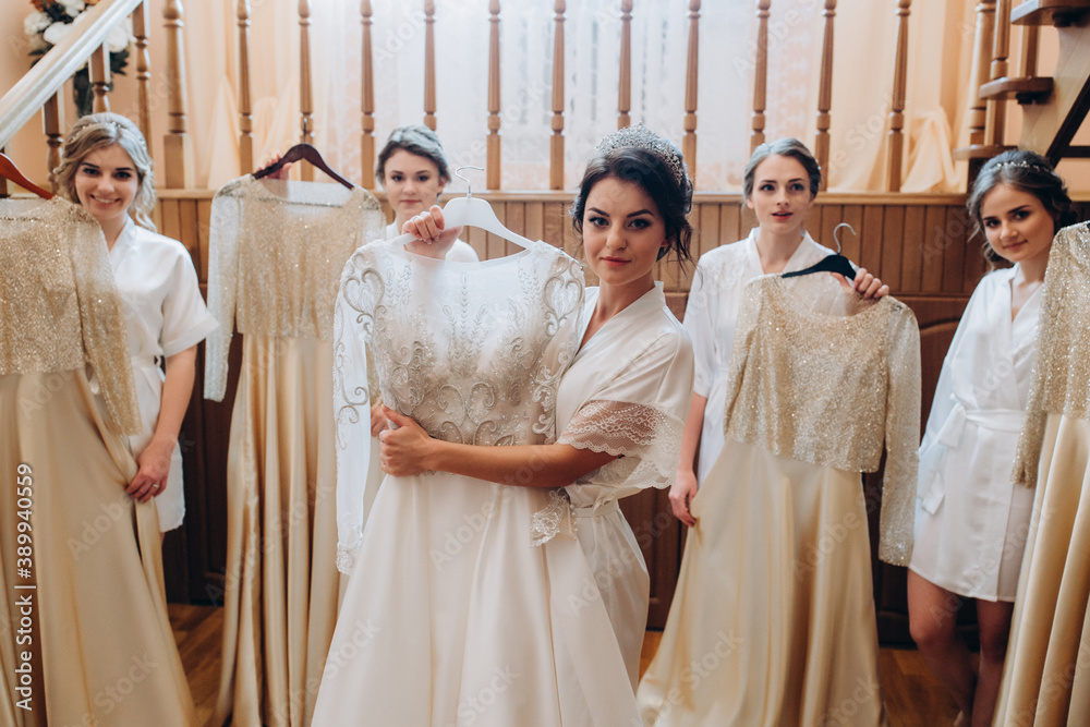 Fototapeta premium Cheerful, young, attractive witnesses next to the bride. Wedding preparations. Fitting dresses.