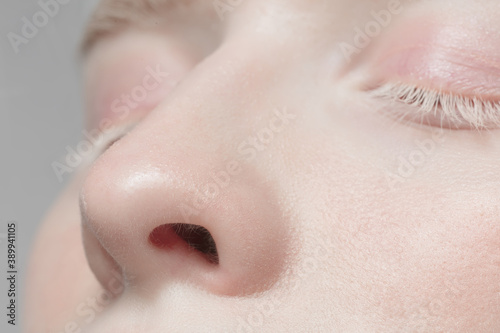 Nose and eyelid. Close up portrait of beautiful albino female model. Parts of face and body. Beauty, fashion, skincare, cosmetics, wellness concept. Copyspace. Well-kept skin, fresh look, details.
