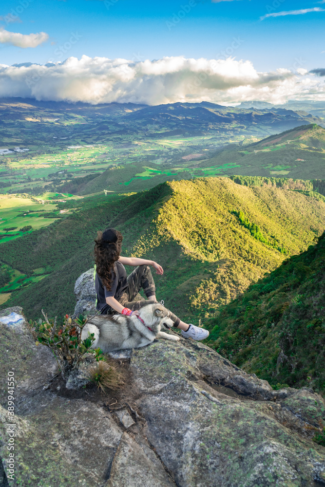Woman sit with her dog after hike a mountain 